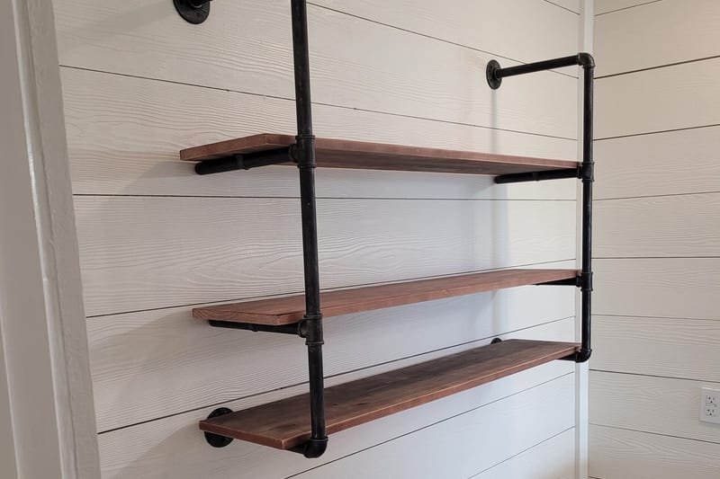 Wood and black pipe shelving on a shiplap bathroom wall