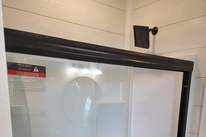 Shower with a black-framed sliding glass door