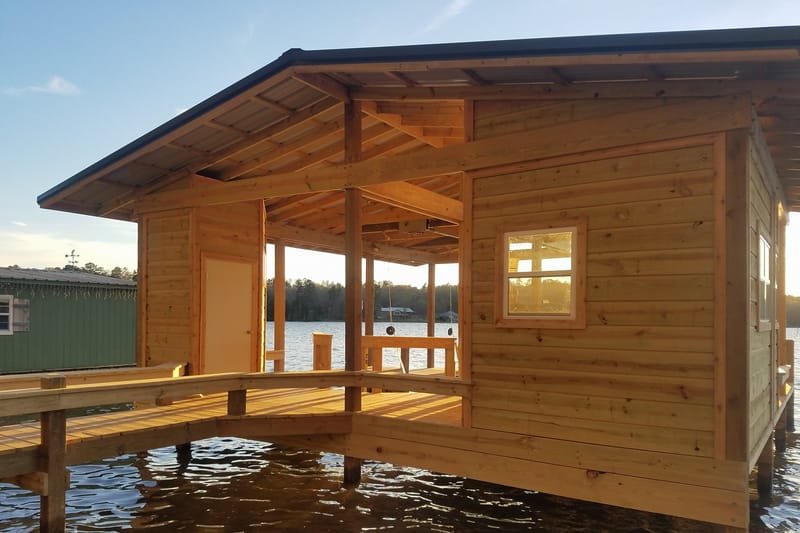 Wood boathouse with windows, reached by a walkway with built-in benches