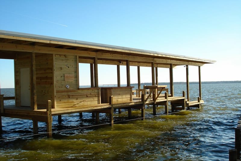 Boathouse with a long covered deck standing over the lake
