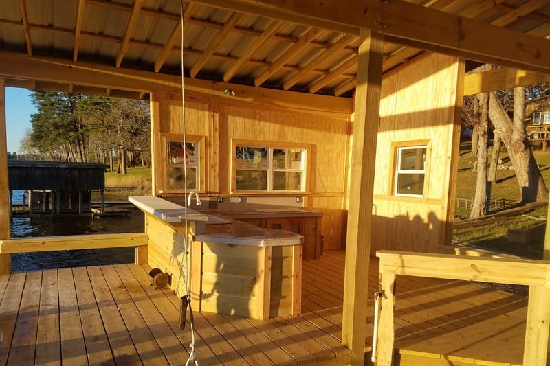 Inside a boathouse, with a sink counter and lift cable over the boat slip