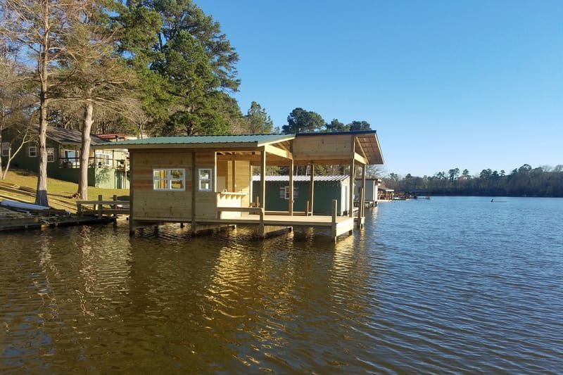 Boathouse with enclosed rooms standing on pilings over the lake