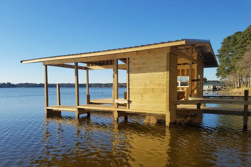 Boathouse with an enclosed room and an open covered deck on the lake
