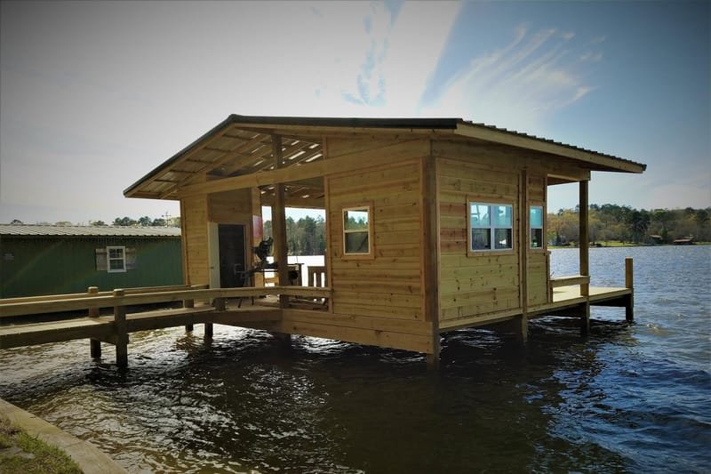 Wood boathouse with windows and a covered porch over the water