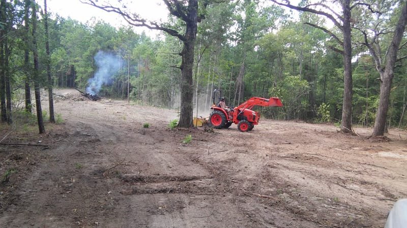 Brush pile burning at the edge of a large cleared area