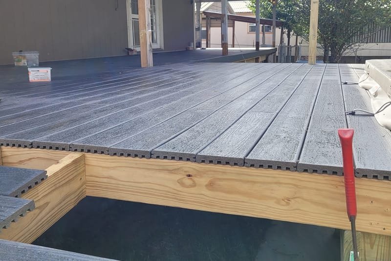 Gray composite deck built off the back porch of a home