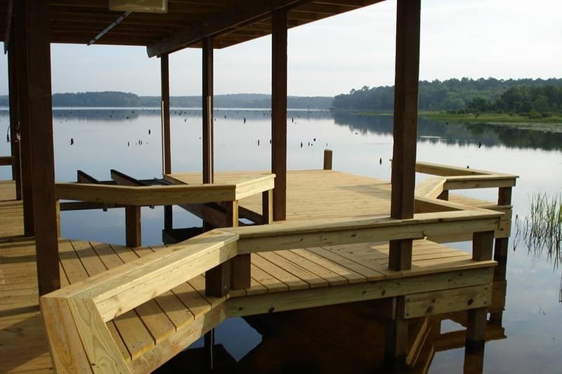Covered pier with built-in benches over calm lake water