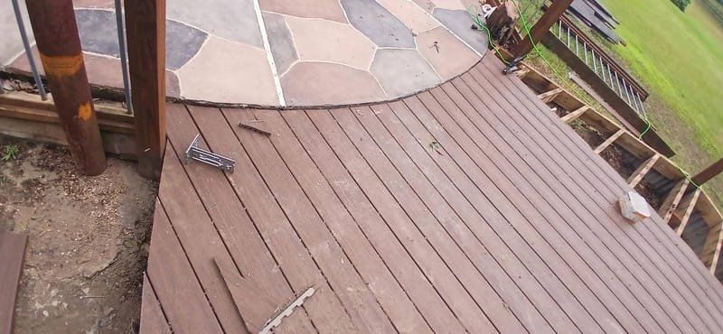 Deck boards being replaced along a stone pool patio