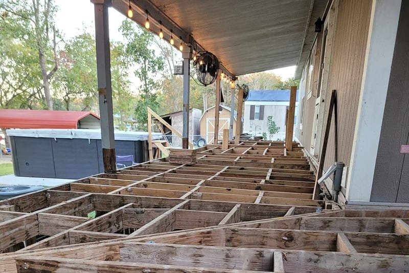 Old deck framing exposed during a porch deck rebuild