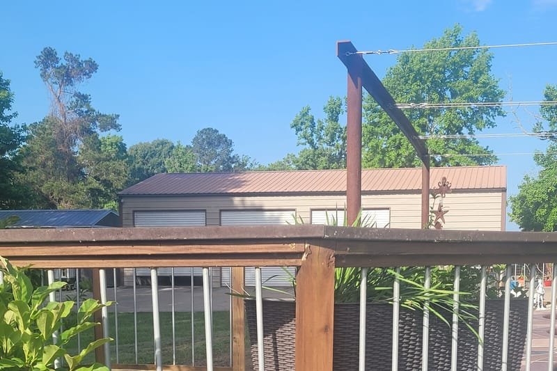 Stained deck railing with metal balusters and metal skirting below