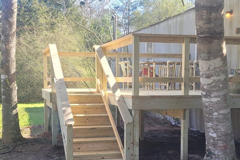 Pressure-treated deck and stairs built beside a large tree