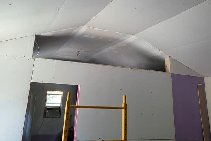 New drywall on the vaulted ceiling of a portable building