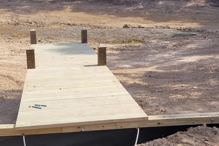 New wood dock walkway over a bulkhead at a private pond