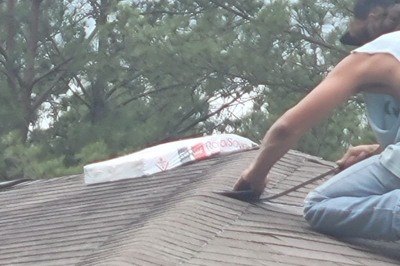 Roofer working on an asphalt shingle roof