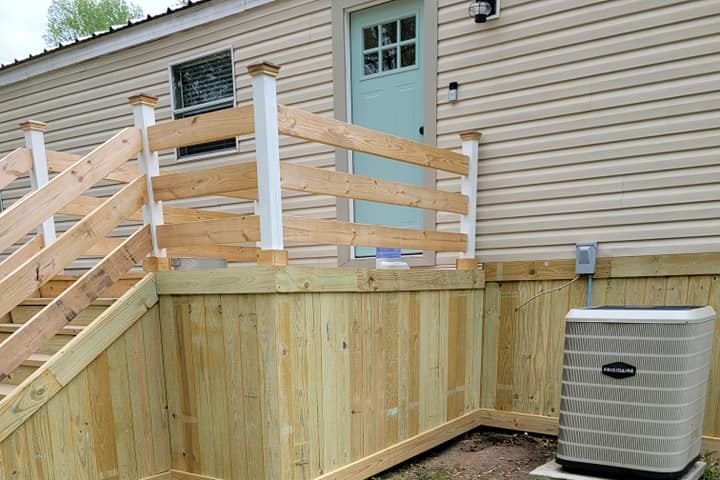 Pressure-treated wood skirting around a mobile home, with matching porch railing