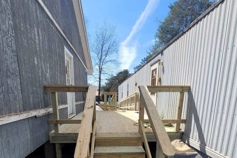 New wooden steps with handrails at a mobile home door