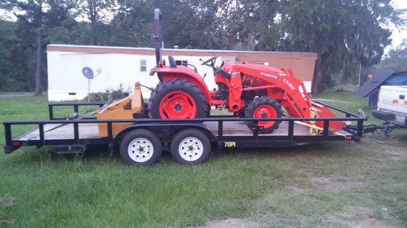 Compact tractor loaded on a trailer
