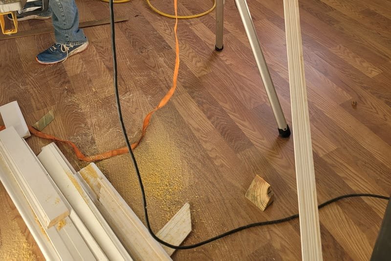 Miter saw set up for trim work in a room with new flooring